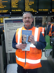 A Scot Rail employee at Waverley Station in Edinburgh on launch day with a copy of Darwin: a graphic biography.