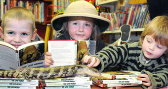 Barry the blue-tongued skink explores some Lost World books at St Austell Library with three new friends.